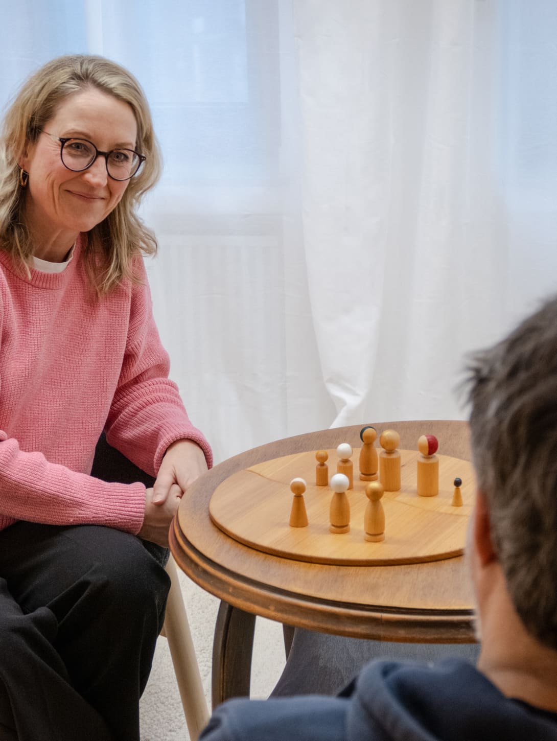 Systemische Beratung, bei der Klienten ihre Situation mit dem Familienbrett visualisieren und besprechen.